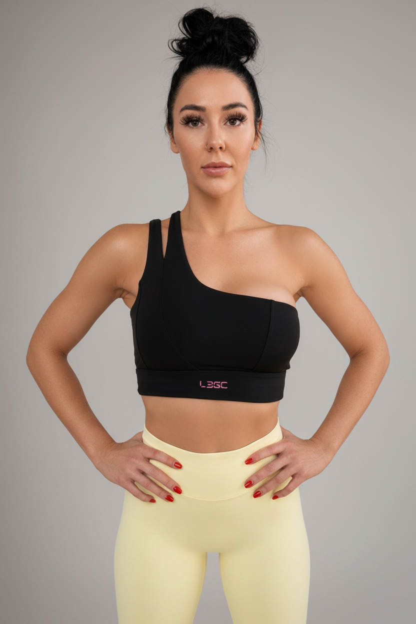 Woman wearing a black sports bra with a visible brand logo on a gray background
