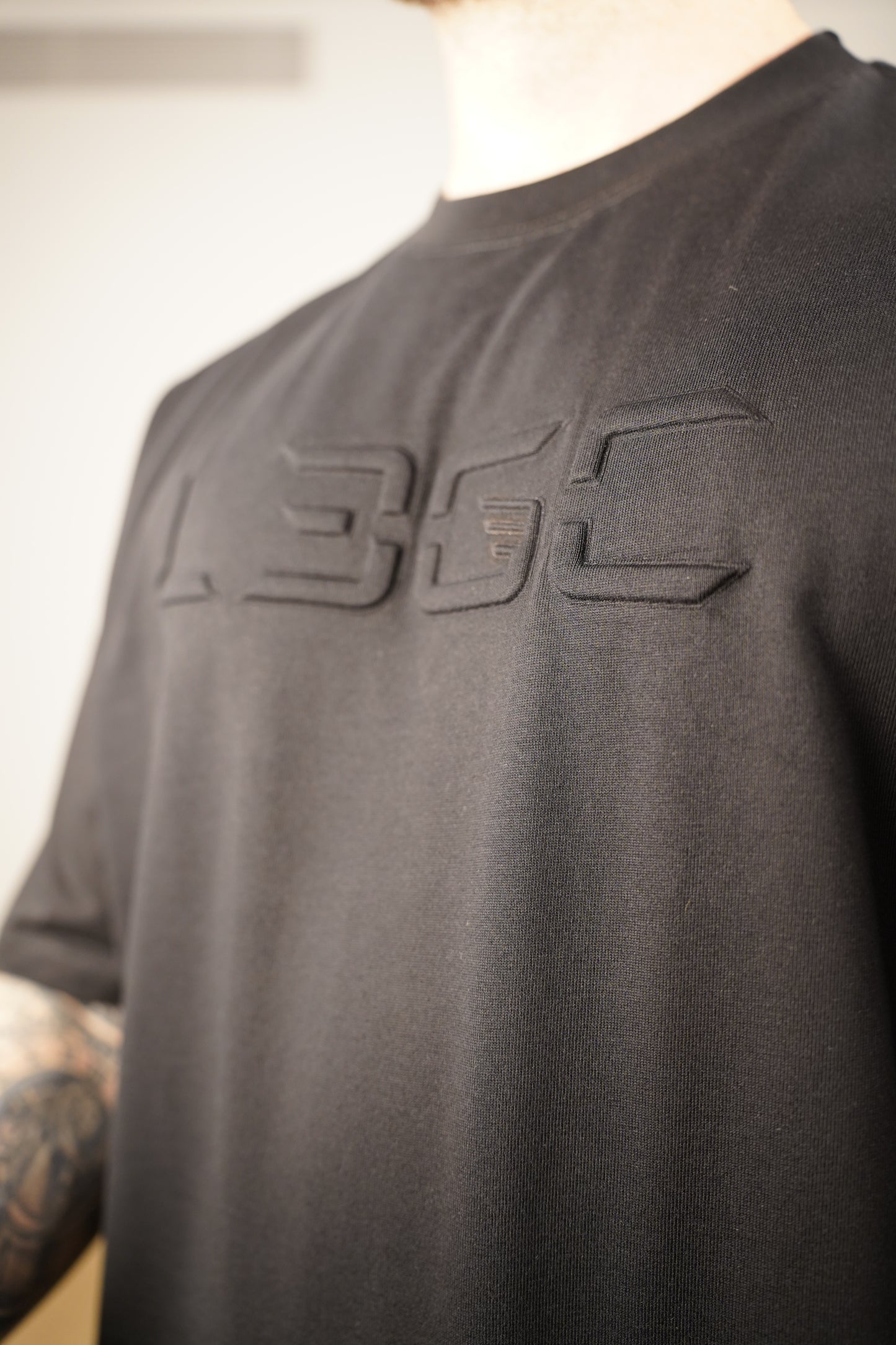 Black shirt with a logo on a person wearing it.