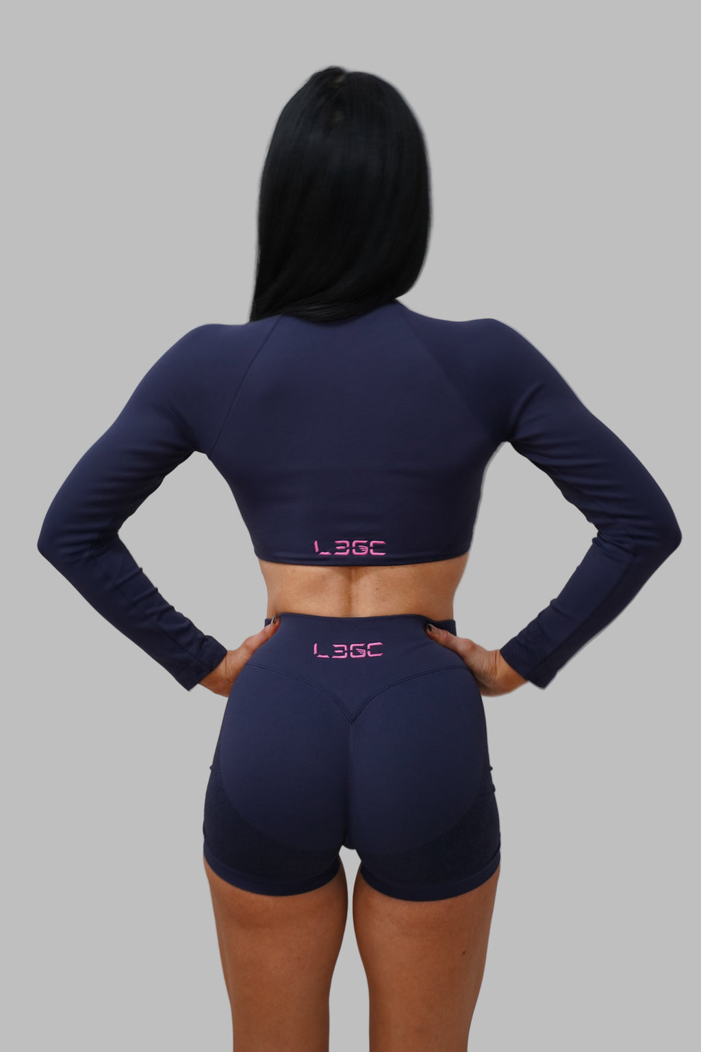 woman wearing navy blue athletic outfit with 'LEGC' branding.