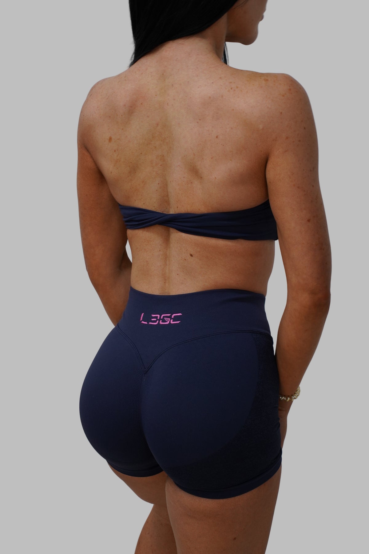 woman wearing navy blue active wear with pink logo