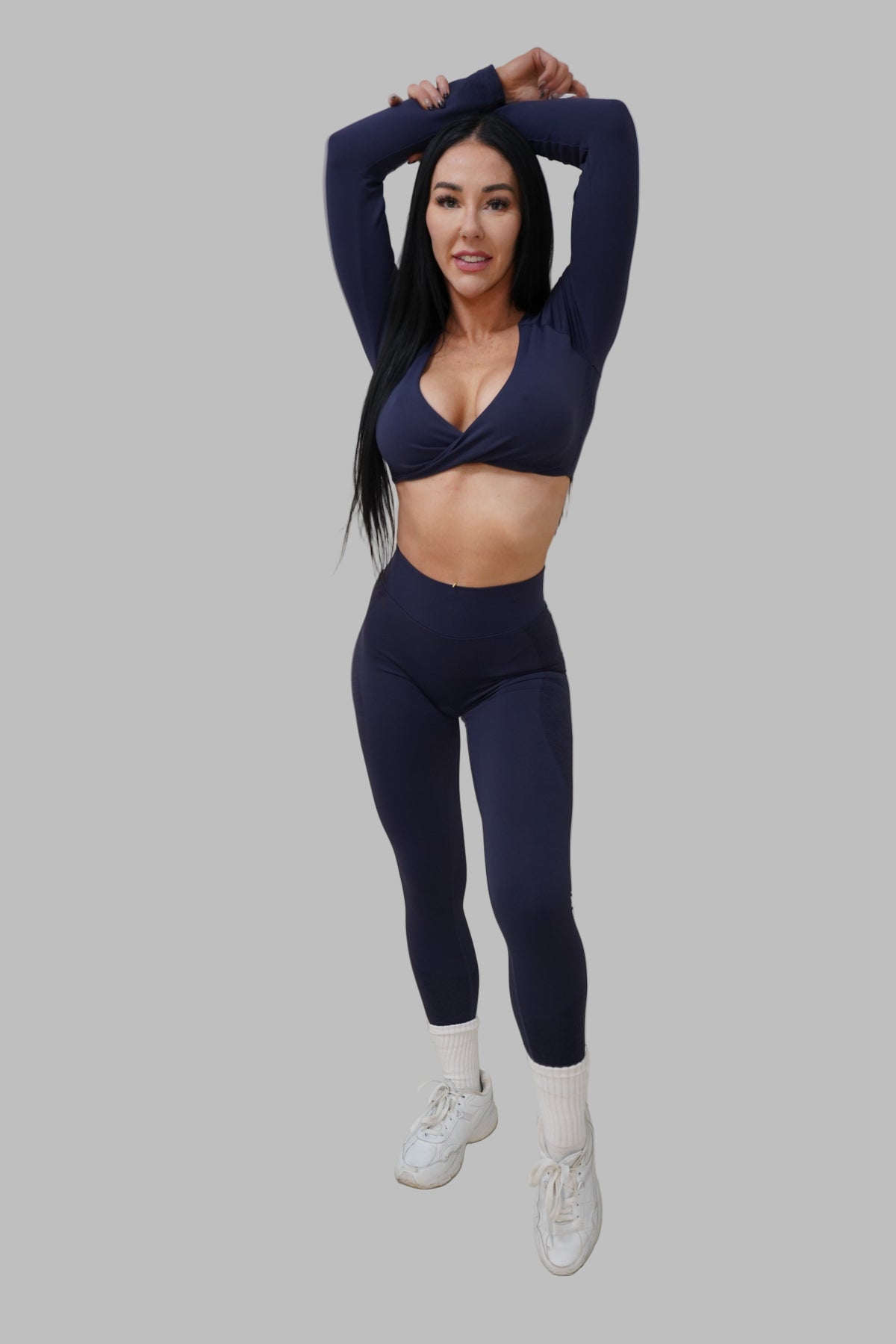 Woman in navy blue athletic outfit posing..