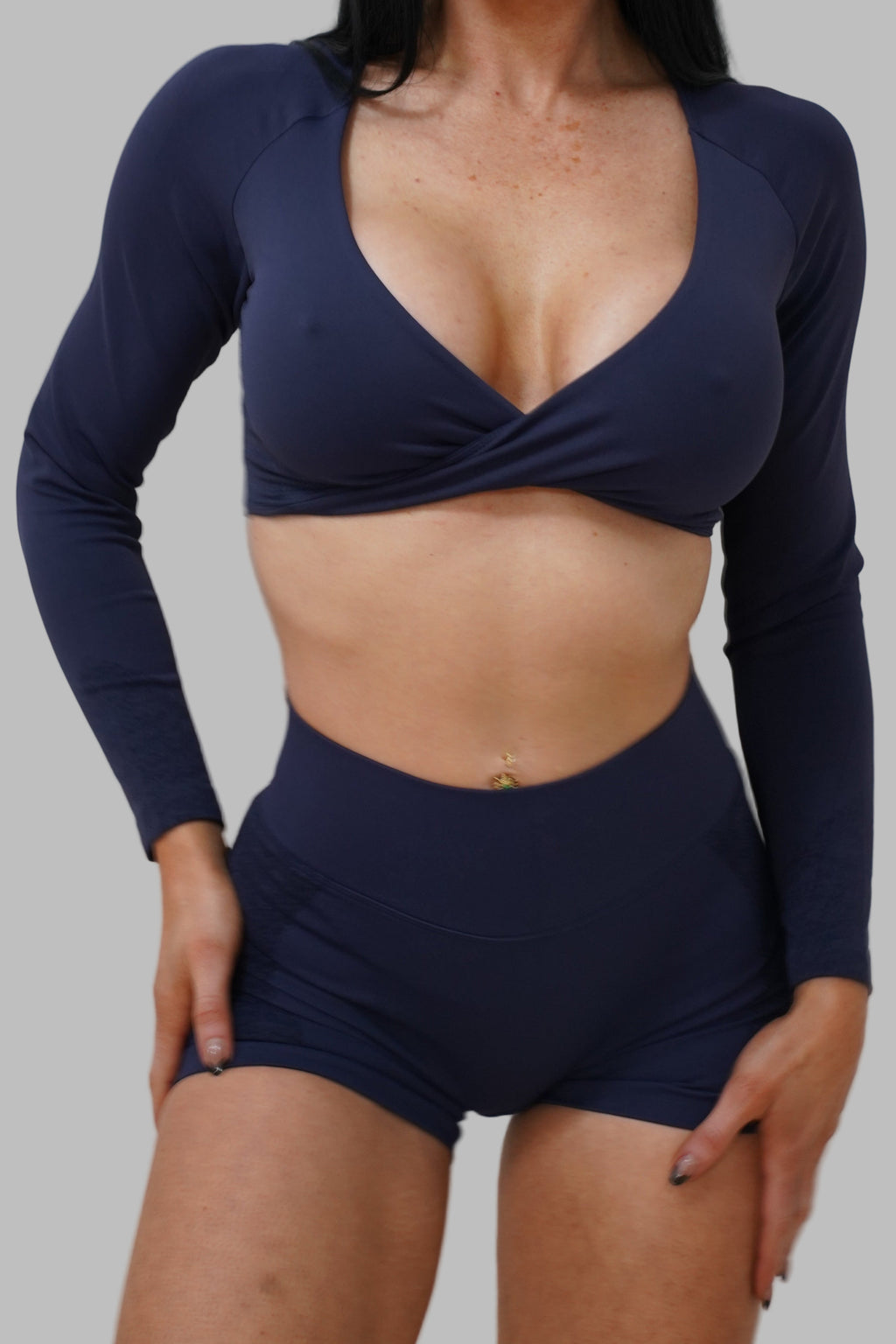 Woman wearing a navy blue long-sleeve top and shorts.