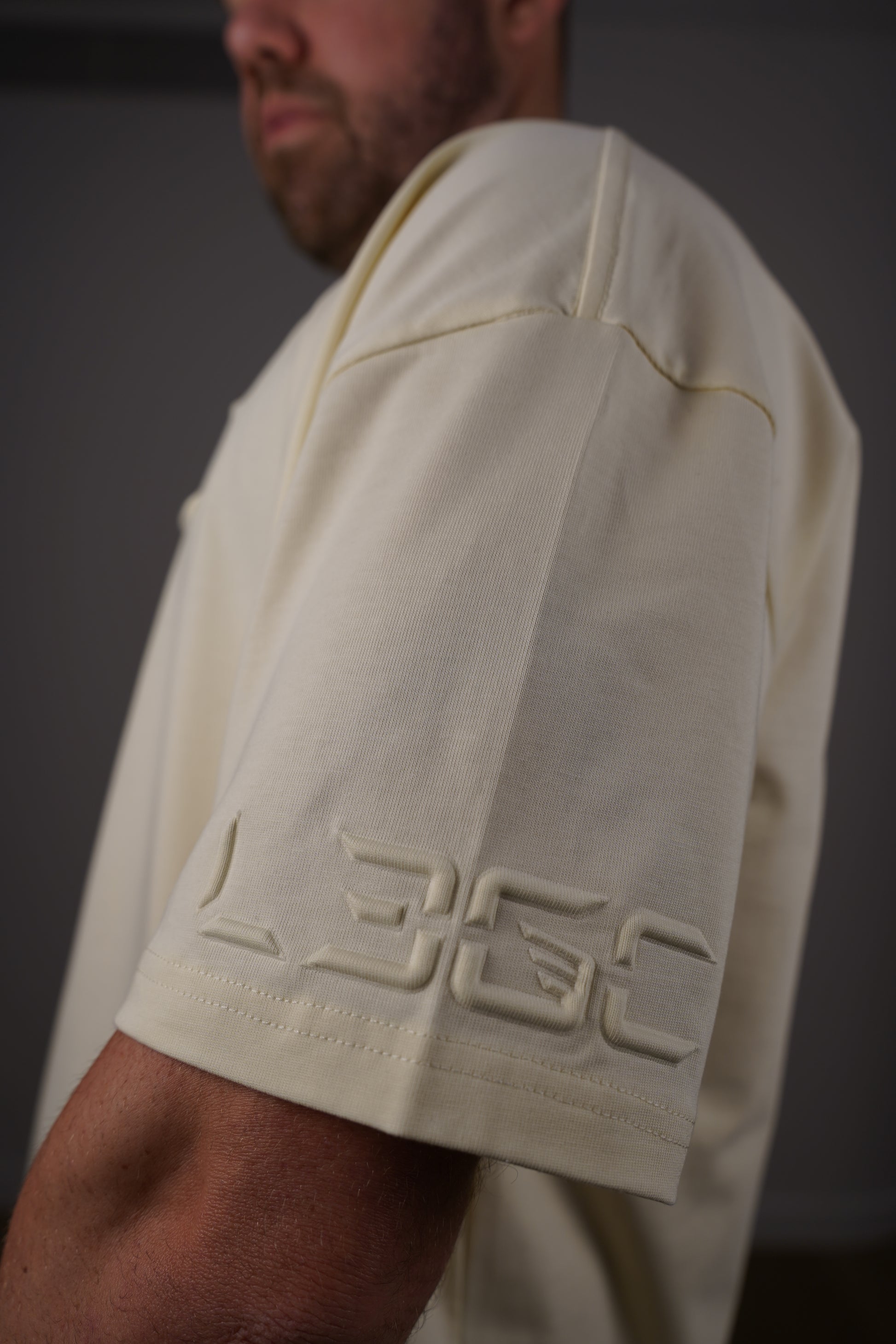 Close-up of a white garment with a brand logo on a dark background