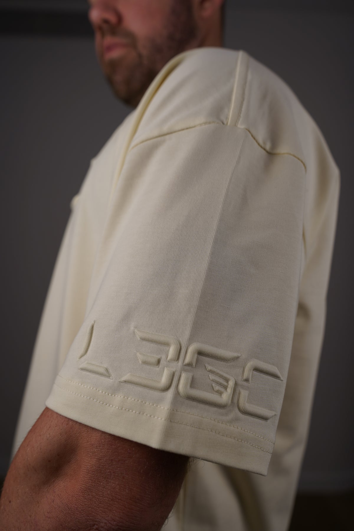 Close-up of a white garment with a brand logo on a dark background