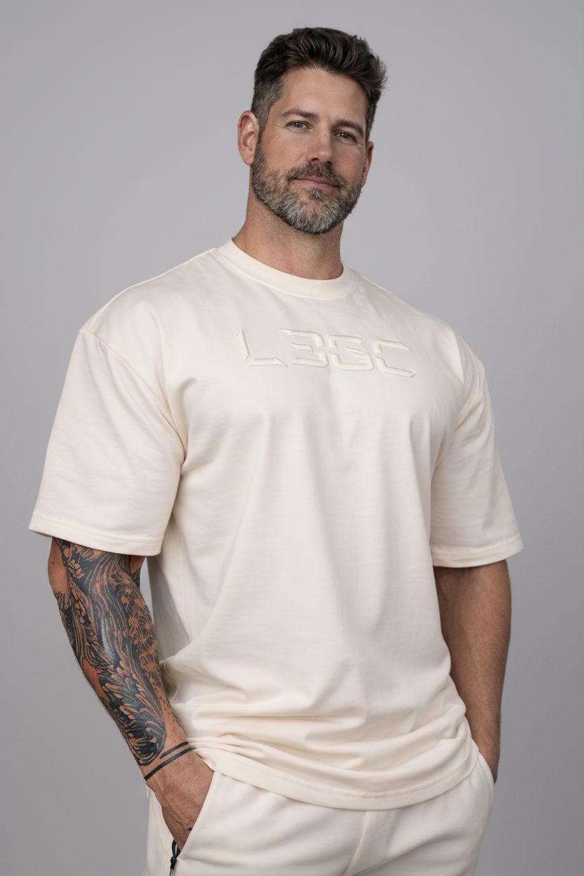 Man wearing a white t-shirt with a logo in a studio setting