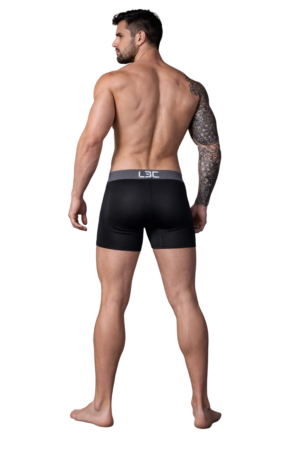 Man wearing black boxer briefs with a visible brand logo on a dark background
