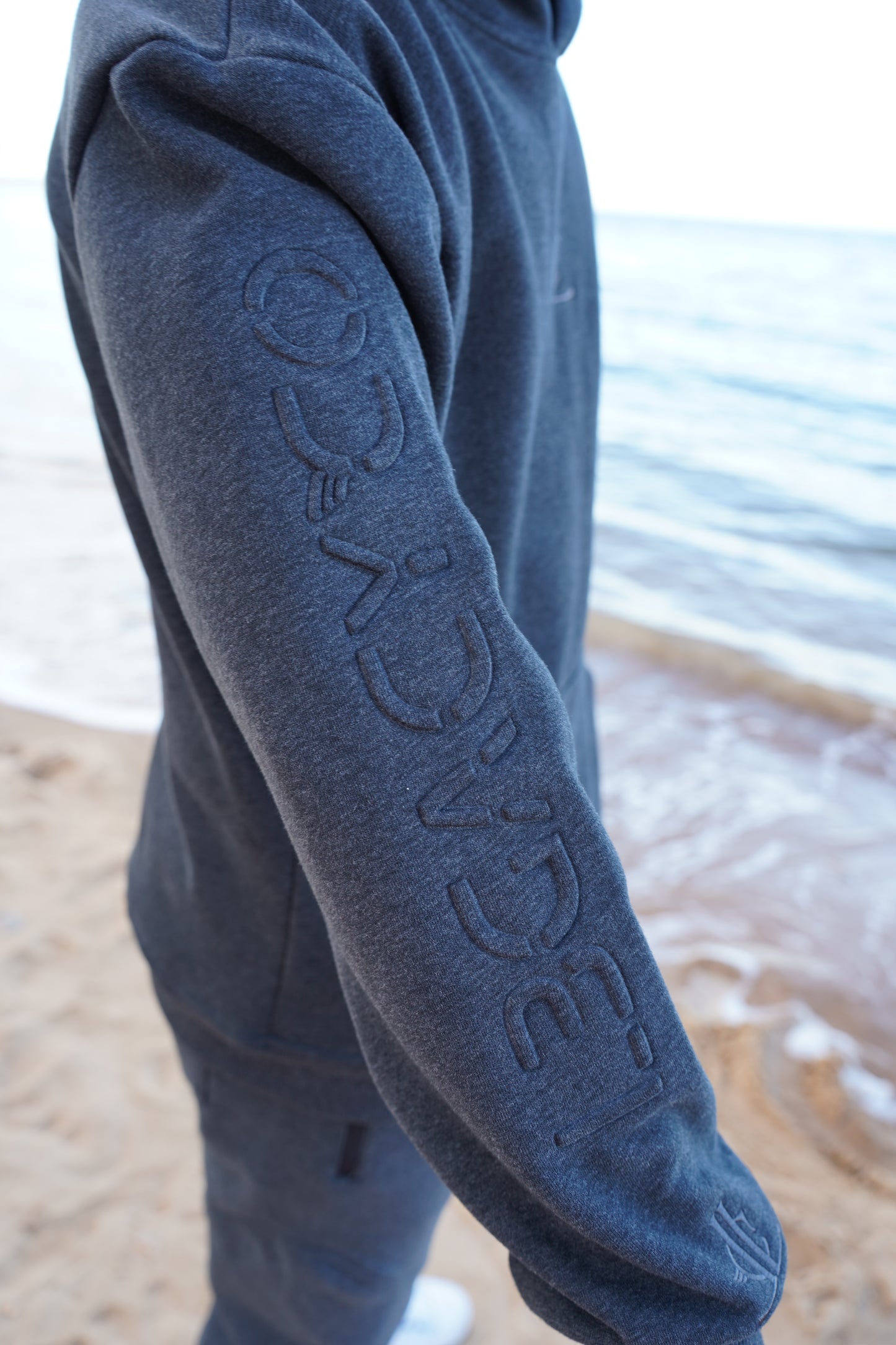 Close-up of a blue sleeve with 'Legacy Co' branding on a blurred background