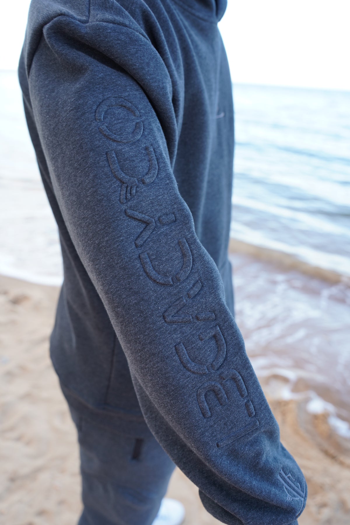 Close-up of a blue sleeve with 'Legacy Co' branding on a blurred background