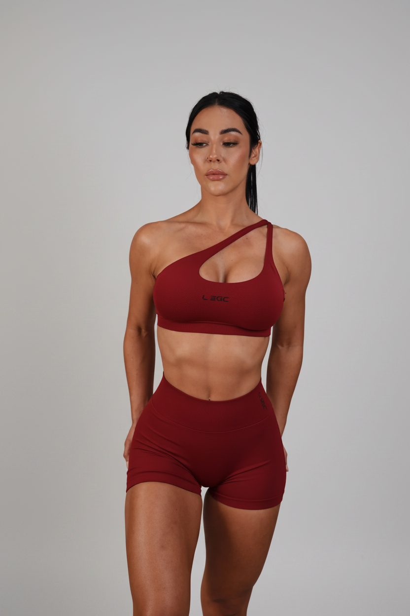Woman wearing a red sports bra and shorts set on a white background