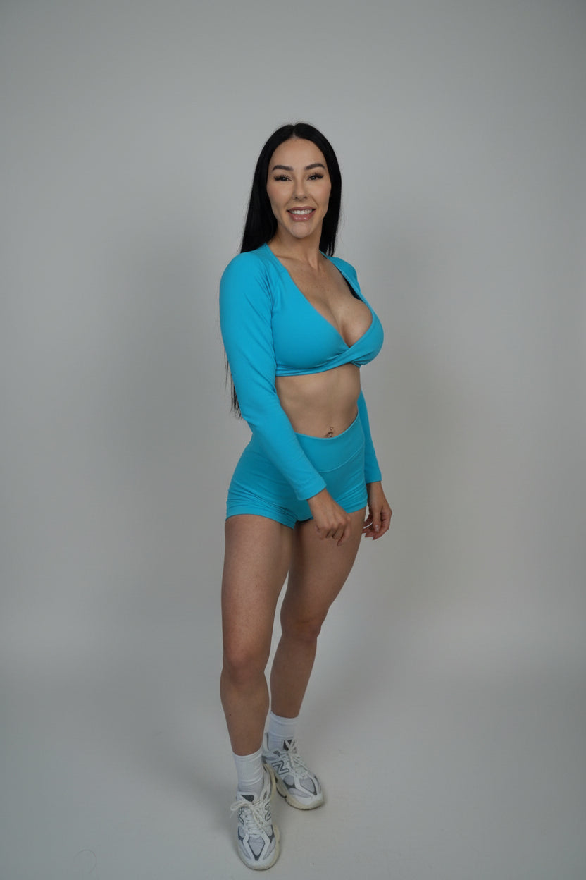 Woman wearing a blue athletic outfit on a black background