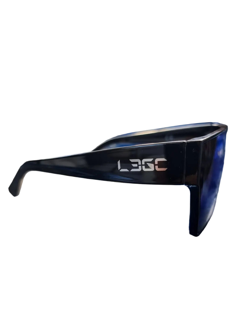A pair of black sunglasses with a silver logo 'LEGC' etched on the temples, placed on a blue surface with foliage in the background.