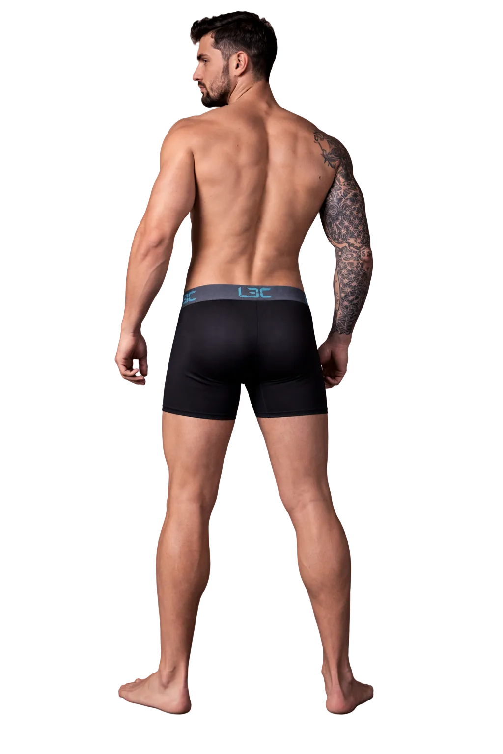 Man wearing black boxer briefs with a visible brand logo on a dark background