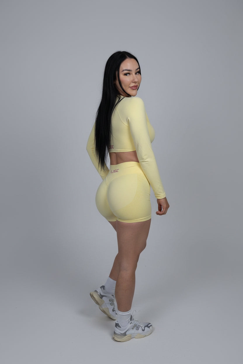 Woman wearing a yellow athletic outfit on a black background